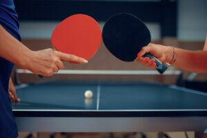 Women holds ping pong rackets, table tennis