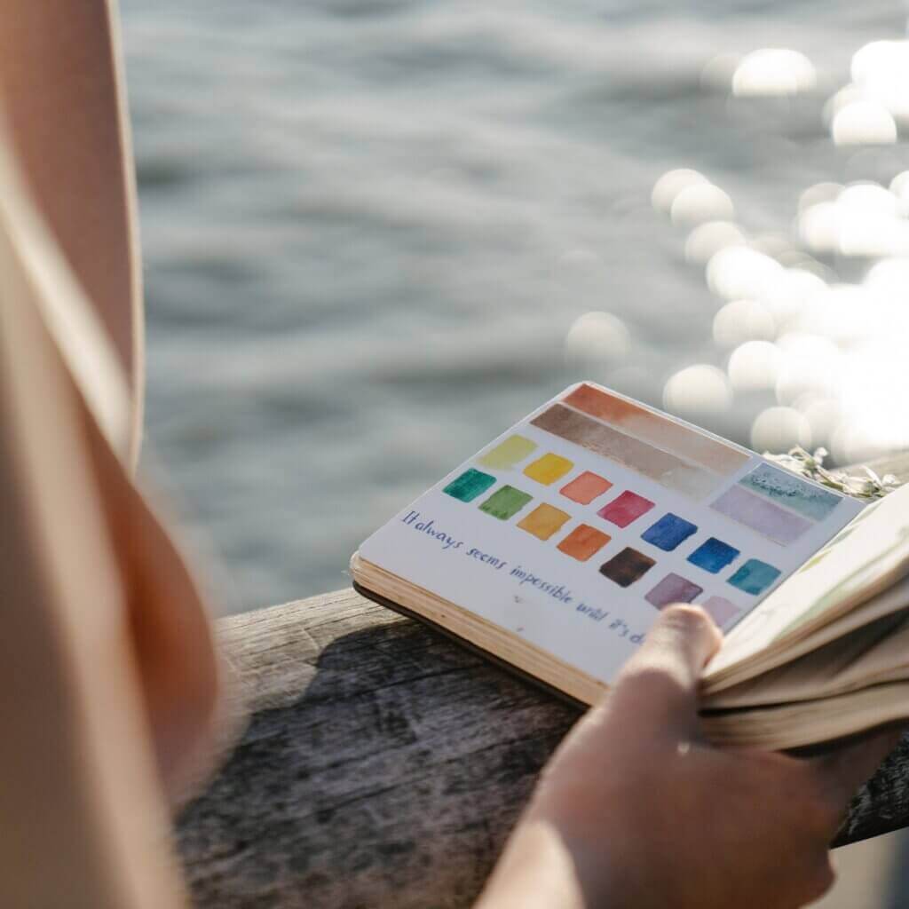 Person holding an art journal for emotional self-care